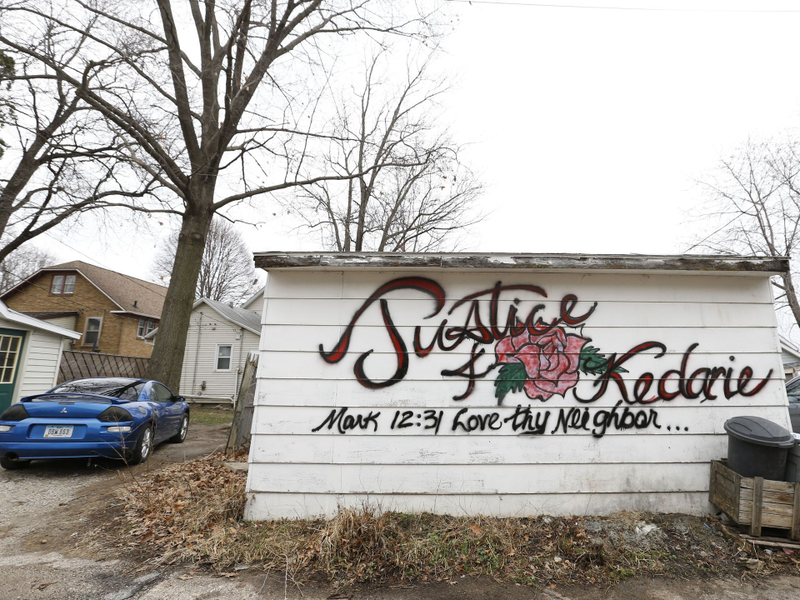 The side of a garage was tagged with a memorial for Kedarie Johnson in the alley where they were found dead March 2, 2016, in Burlington, Iowa. (Michael Zamora/Des Moines Register)